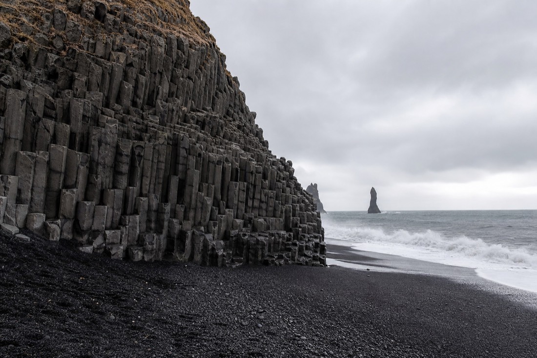 Hexagonal basalt columns and dark surf at Reynisfjara beach near Vik on Iceland's south coast