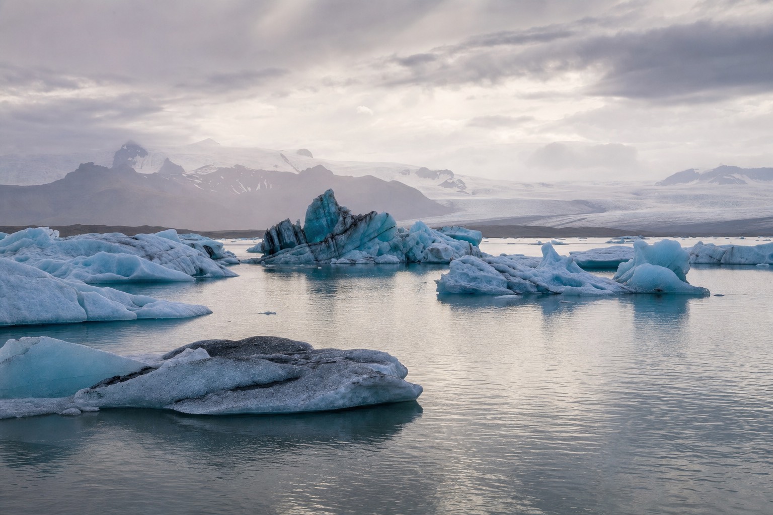 Icebergs drifting on Jökulsárlón glacier lagoon under low light, the setting used in James Bond and Batman films