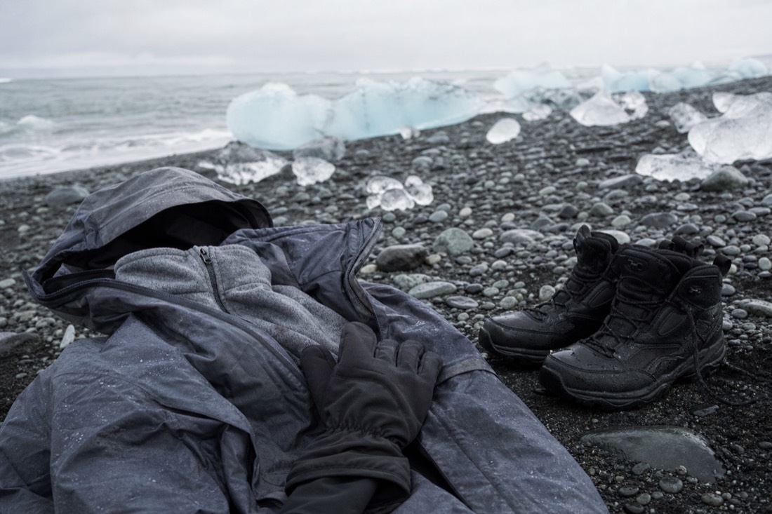 Waterproof shell, fleece, gloves and grippy boots laid out for a winter day at Diamond Beach Iceland